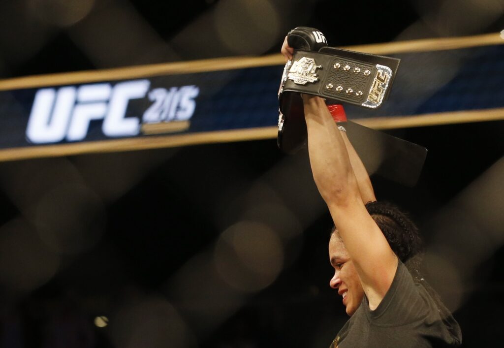 Sep 9, 2017; Edmonton, Alberta, Canada;  Amanda Nunes (red gloves) celebrates with the championship belt after defeating Valentina Shevchenko (blue gloves) during UFC 215 at Rogers Place. Mandatory Credit: Perry Nelson-USA TODAY Sports