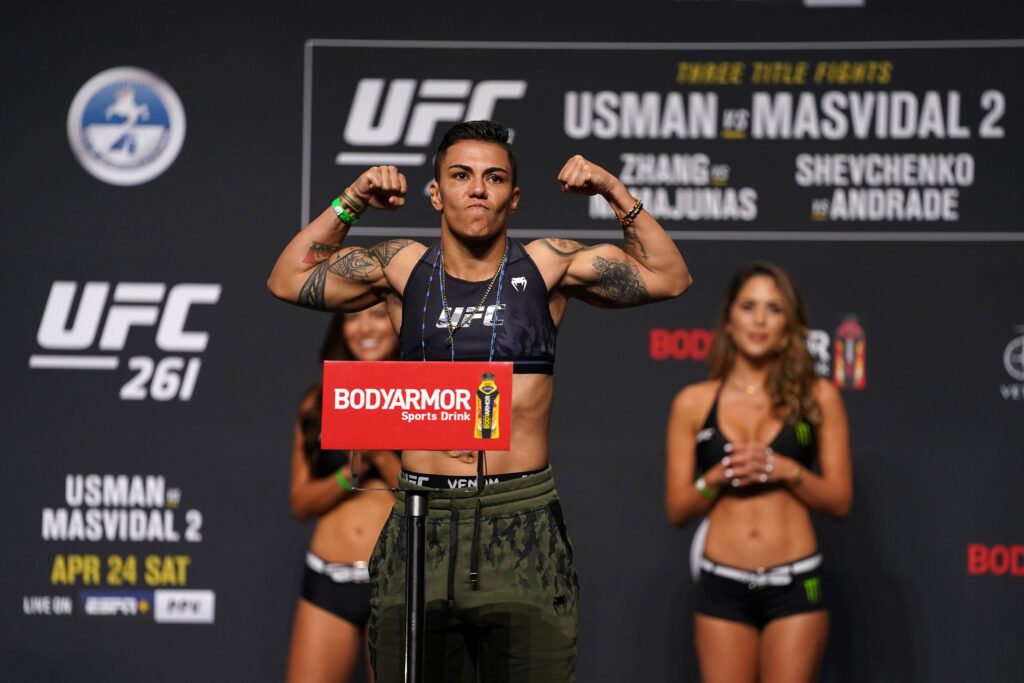 Apr 23, 2021; Jacksonville, Florida, USA; Jessica Andrade flexes while on the scale during weigh-ins for UFC 261 at VyStar Veterans Memorial Arena. Mandatory Credit: Jasen Vinlove-USA TODAY Sports