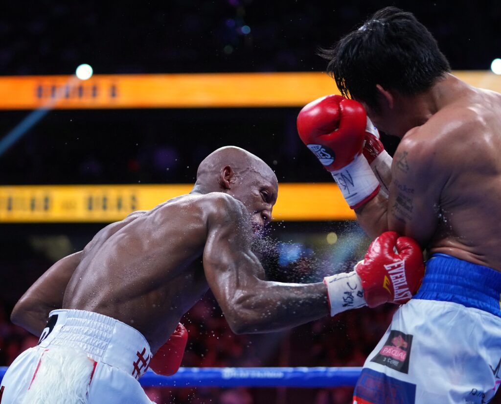 Aug 21, 2021; Las Vegas, Nevada; Manny Pacquiao (right) fights Yordenis Ugas in a world welterweight championship bout at T-Mobile Arena. Mandatory Credit: Stephen R. Sylvanie-USA TODAY Sports