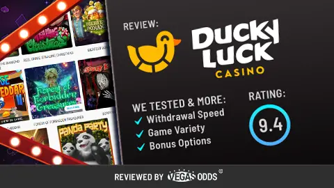Image of Ducky Luck Casino review showing the Ducky Luck Casino logo on the top right, a score of 9.4 in a blue circle below, and a bullet point list of what has been tested in the review. On the left-hand side, there is an image of slot games available at the casino inside a Vegas-style sign.